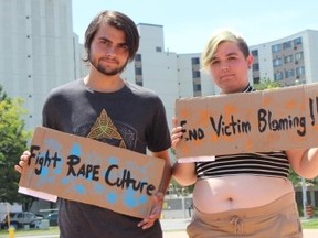 Nathaniel Downer, 17 and Machenzie Moynihan, 17 hold signs which protest victim blaming and rape culture during Belleville's SlutWalk Saturday.