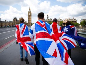People walk over Westminster Bridge wrapped in Union flags, towards the Queen Elizabeth Tower (Big Ben) and The Houses of Parliament in central London on June 26. (AFP PHOTO)