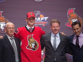 Logan Brown stands on stage with members of the Ottawa Senators front office and coaching staff, including head coach Guy Boucher, at the NHL draft in Buffalo on June 24, 2016. (THE CANADIAN PRESS/Nathan Denette)