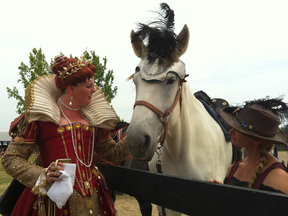A woman who would only give her name as Queen Elizabeth I pets a horse named Penelope at the Oxford Renaissance Festival at the Dorchester Fairgrounds on June 26, 2016. Organizers estimated about 4,000 people attended the weekend event. (AZZURA LALANI, The London Free Press)
