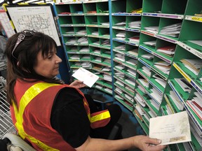 Canada Post worker Barb Hauk hand sorts hard to read cards and letters at the Canada Post Processing Plant in the West end in Edmonton.