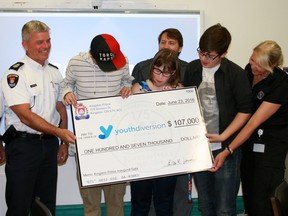 From left, Kingston Police Chief Gilles Larochelle and Staff-Sgt. Jodie Armstrong and Const. Julia Moore (Far right)  present members of Youth Diversion and executive director Shawn Quigley with $107,000 in Kingston, Ont. on Thursday June 23, 2016. The funds were raised from the 175th Anniversary Gala'sticket sales, donations, silent auction, and sponsors. Steph Crosier/Kingston Whig-Standard/Postmedia Network