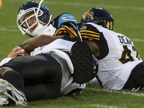 Argos quarterback Ricky Ray is sacked by the Ticats’ Larry Dean during Toronto’s home loss Thursday.  (CHRIS YOUNG/The Canadian Press)