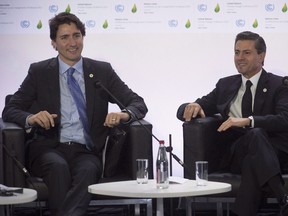 Prime Minister Justin Trudeau laughs as he speaks with Mexican President Enrique Pena Nieto during a session on carbon pricing at the United Nations climate change summit, in Le Bourget, France, in this Nov. 30, 2015 file photo. A plan on how Canada will meet a promise to lift visas for Mexicans will be announced later this month when Prime Minister Justin Trudeau hosts Mexico's president as part of the Three Amigos summit. (THE CANADIAN PRESS/Adrian Wyld)