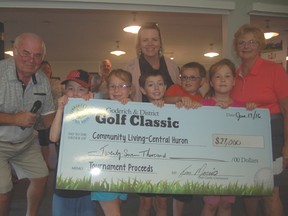 Youngsters Kimble and Xander Ryan and Jordan, Jerzy and Tristan Cobourn, along with CL-CH employee Natalie Steenstra, Coordinator, Huron Respite Network (rear), presented a cheque for $27,000 (later tallies boosted the tournament proceeds to $30,000) to tournament chairman, Tom Morris (left) and his wife, Margo (right) after the annual charity golf tournament June 17. (Photo courtesy of Dave Sykes)