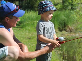 Dan Shetler shows his son, Kevin, how to fish at the annual family fishing derby at Falls Reserve Conservation Area on June 25. Participants were fishing for the biggest bass and trout at the conservation area’s pond. (Laura Broadley/Goderich Signal Star)