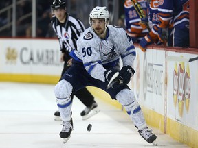 Manitoba Moose forward Austen Brassard dumps the puck into the Bakersfield Condors zone during AHL action in Winnipeg on Fri., Nov. 20, 2015. Kevin King/Winnipeg Sun/Postmedia Network