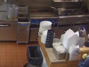 A screengrab of a security footage showing a man breaking in to a restaurant and dousing himself in powdered sugar.