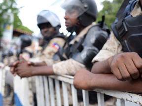 Police officers protect the electoral council office in Petion-ville, Haiti on June 7, 2016.    / AFP PHOTO / Fabienne Douce