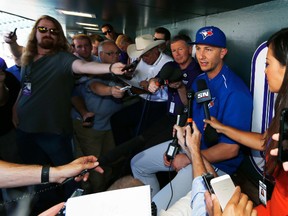 Toronto Blue Jays shortstop Troy Tulowitzki , back right, is pinned against the wall of the visitor's dugout as he holds a news conference before facing the Colorado Rockies on June 27, 2016, in Denver. Tulowitzki made his first appearance in Denver since he was traded last July by the Rockies to Toronto. (DAVID ZALUBOWSKI/AP)