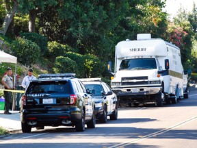Police stand in front of a home in Rancho Santa Fe, Calif. where three people were found dead on Monday, June 27, 2016. (Hayne Palmour IV/San Diego Union-Tribune via AP)