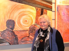 Gunhild Hotte stands beside one of her pieces on display at the Art Gallery at the Cochrane Public Library. The exhibit is a passion portrayal of the elimination of the Northlander.