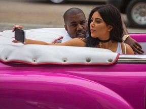 American reality-show star Kim Kardashian takes a selfie as she rides on a classic car next to her husband, rap superstar Kayne West in Havana, Cuba, Wednesday, May 4, 2016. West, Kardashian and members of her reality-show-star family have become the latest celebrities to visit Havana. They visited Havana’s Museum of Rum Wednesday, stepping out of a hot-pink antique American convertible as they snapped selfies and were recorded by a television crew following them around.(AP Photo/Desmond Boylan)