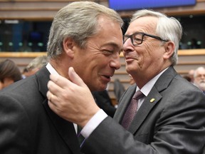 European Commission President Jean-Claude Juncker, right, greets UKIP leader Nigel Farage during a special session of European Parliament in Brussels on Tuesday, June 28, 2016. EU heads of state and government meet Tuesday and Wednesday in Brussels for the first time since Britain voted to leave the European Union, throwing British and European politics into disarray. (AP Photo/Geert Vanden Wijngaert)
