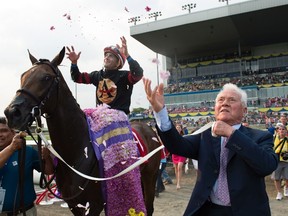 Jockey Rafael Hernandez and owner Frank Stronach toss flowers in the air after Shaman Ghost won last year’s Queen’s Plate. (THE CANADIAN PRESS)