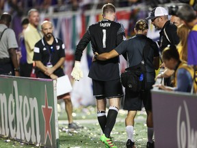 Toronto FC goalkeeper Clint Irwin is helped off the field after suffering a quad strain on Saturday against Orlando. (AP)