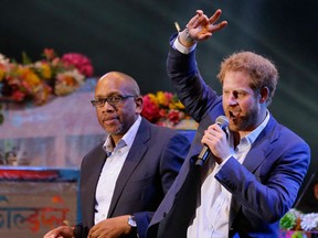 Britain's Prince Harry, right, flanked by Lesotho's Prince Seeiso, center, acknowledges the crowd as Coldplay perform at the end of the finale performance of an outdoor concert hosted by Harry's charity Sentebale in Kensington Palace Gardens, in London, Tuesday, June 28, 2016. The concert is to raise awareness and funds for adolescents living with HIV in sub-Saharan Africa. (AP Photo/Matt Dunham, Pool)