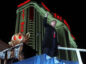 In this April 5, 1990 file photo, Donald Trump raises his fist during ceremonies for the opening the Trump Taj Mahal Casino Resort in Atlantic City, N.J. (AP Photo/Charles Rex Arbogast, File)