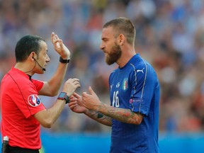 Referee Cuneyt Cakir talks with Italy's Daniele De Rossi during a Euro 2016 Round of 16 match between Italy and Spain, at the Stade de France, in Saint-Denis, north of Paris, on June 27, 2016. (AP Photo/Manu Fernandez)