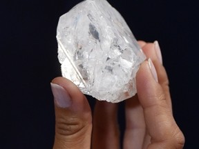 This file photo taken on June 14, 2016 shows a model posing with an uncut 1109-carat diamond named 'Lesedi La Rona', at Sotheby's auction house in London.
The world's largest uncut diamond failed to sell at auction in London on Wednesday as bids failed to reach its reserve price. The Lesedi La Rona, a tennis ball-sized gem found in Botswana, had been estimated to sell for over $70 million. / AFP PHOTO / BEN STANSALLBEN STANSALL/Getty Images