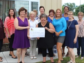 Samantha Reed/The Intelligencer
Angela Sheppard (left) of 100+ Women Who Care Quinte hands a donation to Three Oaks executive director Sandy Watson-Moyles (right) as she's surrounded by members of 100+ Women Who Care on Wednesday afternoon.