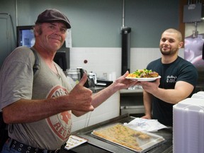 George, shows his pleasure as he's handed a meal by Shelby's Food Express owner Yazan El-Shalabi.
The restaurant, which recently was sending proceeds to Fort McMurray fire victims has now teamed app with the Salvation Army and the London Muslim community to host a free meal for 200 people who live in shelters in London. (MIKE HENSEN, The London Free Press)