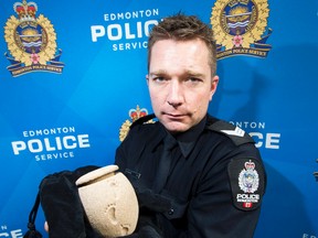 Sgt. Steve Sharpe holds up the lost urn that has since been returned to the Edmonton family that lost it.