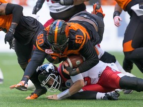B.C. Lions' Mic'hael Brooks (top) recovers the ball after Calgary Stampeders' quarterback Bo Levi Mitchell, bottom, fumbled it during the first half of a CFL football game in Vancouver, B.C., on Saturday June 25, 2016. (DARRYL DYCK/The Canadian Press files)