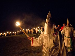In this Saturday, April 23, 2016 photo, members of the Ku Klux Klan participate in cross burnings after a "white pride" rally in rural Paulding County near Cedar Town, Ga. (AP Photo/John Bazemore)