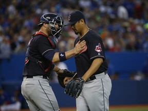 Cleveland Indians catcher Chris Gimenez (38) pats starting pitcher Carlos Carrasco (59) on the chest at the end of the seventh inning at the Rogers Centre on Thursday June 30, 2016. (Jack Boland/Toronto Sun/Postmedia Network)