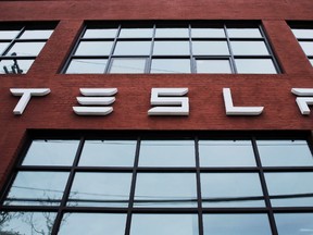 A Tesla logo hang on a building outside of a Tesla dealership in New York, U.S., April 29, 2016. (REUTERS/Lucas Jackson/File Photo)