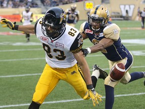 Hamilton Tiger-Cats receiver Andy Fantuz is shoved out of bounds by Winnipeg Blue Bombers DB Matt Bucknor during CFL action in Winnipeg last year. (Postmedia Network file photo)