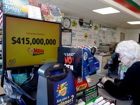 A customer, right, waits for her Mega Millions lottery ticket at a convenience store in Chicago, Friday, July 1, 2016. Friday night's Mega Millions drawing will give lottery players a shot at the 10th largest jackpot in U.S. history. (AP Photo/Nam Y. Huh)