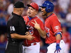 Blue Jays manager John Gibbons (centre) and DH Edwin Encarnacion exchange words with umpire Vic Carapazza after Encarnacion was ejected from the game over a call-out on strikes during first inning MLB action in Toronto on Friday, July 1, 2016. The confrontation resulted in Gibbons also getting ejected from the game. (Frank Gunn/The Canadian Press)