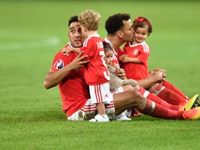 Wales’ James Chester, left, and Hal Robson-Kanu play with their children on the pitch at the end of the Euro 2016 quarterfinal against Belgium at the Pierre Mauroy stadium in Villeneuve d’Ascq, near Lille, France, Friday, July 1, 2016. (AP Photo/Martin Meissner)