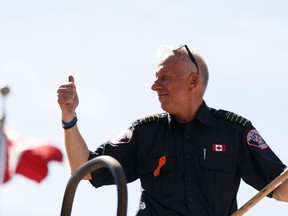 Fire Chief Darby Allen salutes the crowd during the Canada Day parade held in Fort McMurray on Friday, July 1, 2016. Ian Kucerak / Postmedia