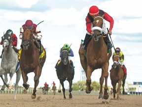 Jockey Eurico Da Silva guides Melmich (red silks) to last-to-first victory in the $150,000 Dominion Day Stakes at Woodbine yesterday. Melmich is owned by Stephen Chesney and Cory Hoffman and trained by Kevin Attard. (Michael Burns, photo)