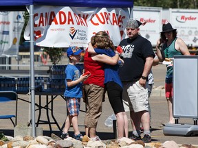A family hugs during the Canada Day celebrations held in Fort McMurray on Friday, July 1, 2016. (For Edmonton Journal story by Juris Graney) Ian Kucerak / Postmedia