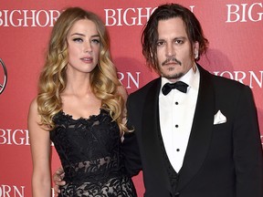 In this Jan. 2, 2016 file photo, Amber Heard, left, and Johnny Depp arrive at the 27th annual Palm Springs International Film Festival Awards Gala in Palm Springs, Calif. A Los Angeles Superior Court spokeswoman says the temporary restraining order Heard obtained against Depp will remain in effect until Aug. 15. (Jordan Strauss/Invision/AP, File)