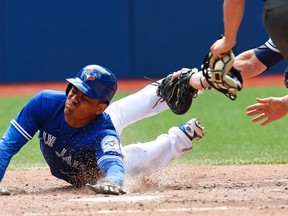 Blue Jays baserunner Ezequiel Carrera slides into home and scores on an RBI single by Josh Donaldson as Indians catcher Chris Gimenez attempts the tag during eighth inning MLB action in Toronto on Saturday, July 2, 2016. (Frank Gunn/The Canadian Press)