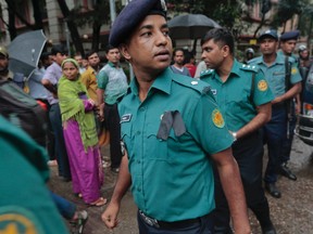 Bangladeshi policemen on duty wear black badges on the first of two days of national mourning for the victims of the attack on the Holey Artisan Bakery in Dhaka, Bangladesh, Sunday, July 3, 2016. The assault on the restaurant in Dhaka's diplomatic zone by militants who took dozens of people hostage marks an escalation in militant violence in the Muslim-majority nation. (AP Photo)