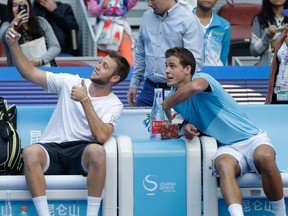 Jack Sock, left, takes a selfie with his partner Vasek Pospisil after winning the men’s doubles at the China Open in Beijing, Sunday, Oct. 11, 2015. (AP Photo/Andy Wong)