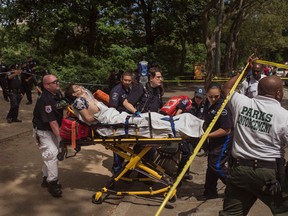 An injured man is carried to an ambulance in Central Park in New York, Sunday, July 3, 2016. Authorities say a man was seriously hurt in Central Park and people near the area reported hearing some kind of explosion. (AP Photo/Andres Kudacki)