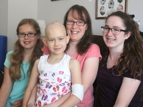 Michaela Stokes-Noonan at her Kingston home with her daughters, from left, Ori, Dani and Andy. Dani, 8, has a rare form of cancer and the family hopes to get her into a treatment program at the Mayo Clinic in Rochester, Minn. (Michael Lea/The Whig-Standard)