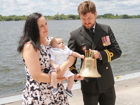 Katrina DuVall, holding four-month-old son Coen, and her husband Lt. David DuVall pose for photos after Coen's traditional navy baptism at HMCS Cataraqui on Saturday. (Julia McKay/The Whig-Standard)