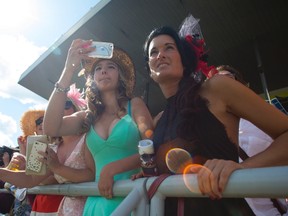 Race goers watch the ninth race on the card ahead of the Queen’s Plate at Woodbine on Sunday. The event succeeded in bringing in a younger crowd. (THE CANADIAN PRESS)