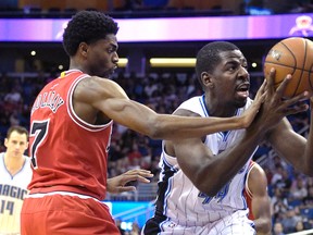 Orlando Magic forward Andrew Nicholson (right) is fouled by Chicago Bulls guard Justin Holiday while driving to the basket during an NBA game in Orlando, Fla., Saturday, March 26, 2016. (AP Photo/Phelan M. Ebenhack)