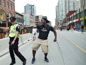 Yves Soglo dances with a member of Ottawa Police Service officer Tracey Turpin on Canada Day, July 1, 2016.