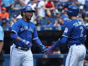 Edwin Encarnacion of the Toronto Blue Jays (left) is congratulated by Troy Tulowitzki after scoring a run in the eighth inning of Toronto's game against the Cleveland Indians on July 3, 2016 at Rogers Centre in Toronto. (TOM SZCZERBOWSKI/Getty Images)