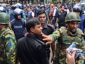 Bangladeshi police and military gather in an intersection near an upscale restaurant after a bloody siege ended in Dhaka on July 2, 2016. (STR/AFP/Getty Images)